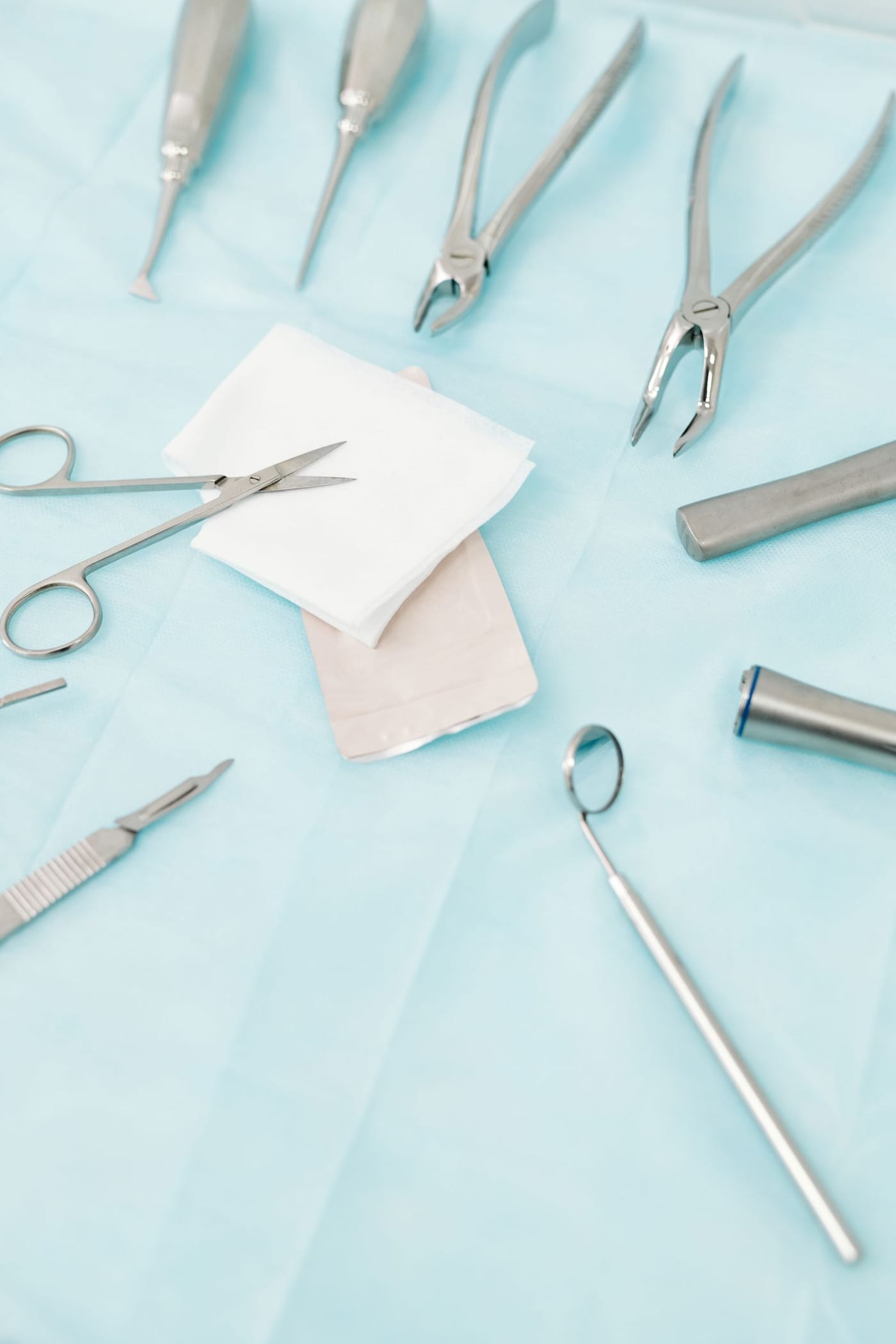Stainless steel dental instruments laid out on a sterile cloth